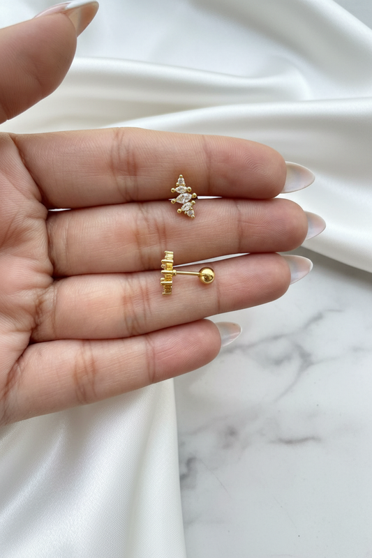 Gold crystal marquise cross stud earrings showing front and ball-back closure on white satin marble background
