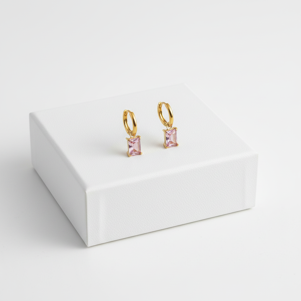 Pink Drop Huggies displayed on white jewelry box