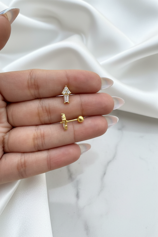 Gold crystal floral cluster baguette drop stud earrings showing front and ball-back closure on white satin marble background