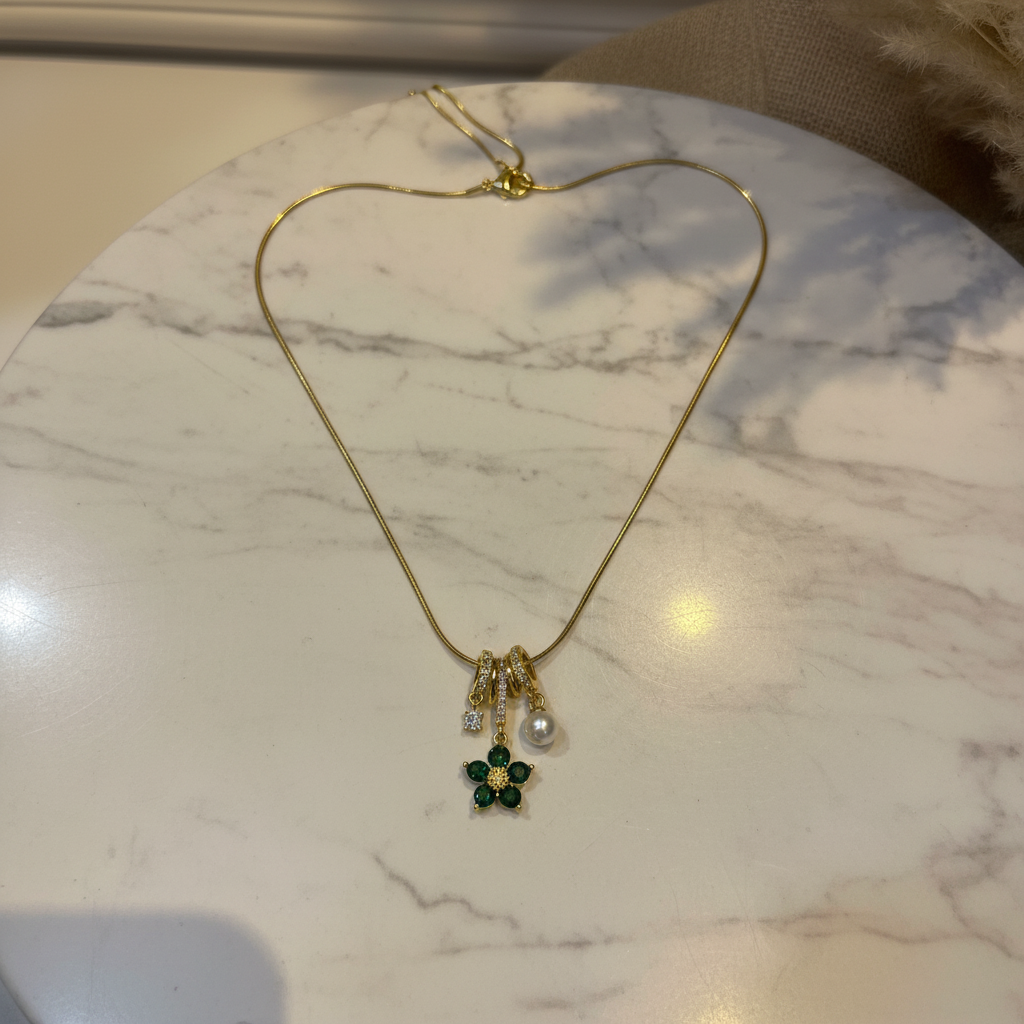 Green Flower Charm Necklace flat lay on white marble