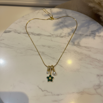 Green Flower Charm Necklace flat lay on white marble