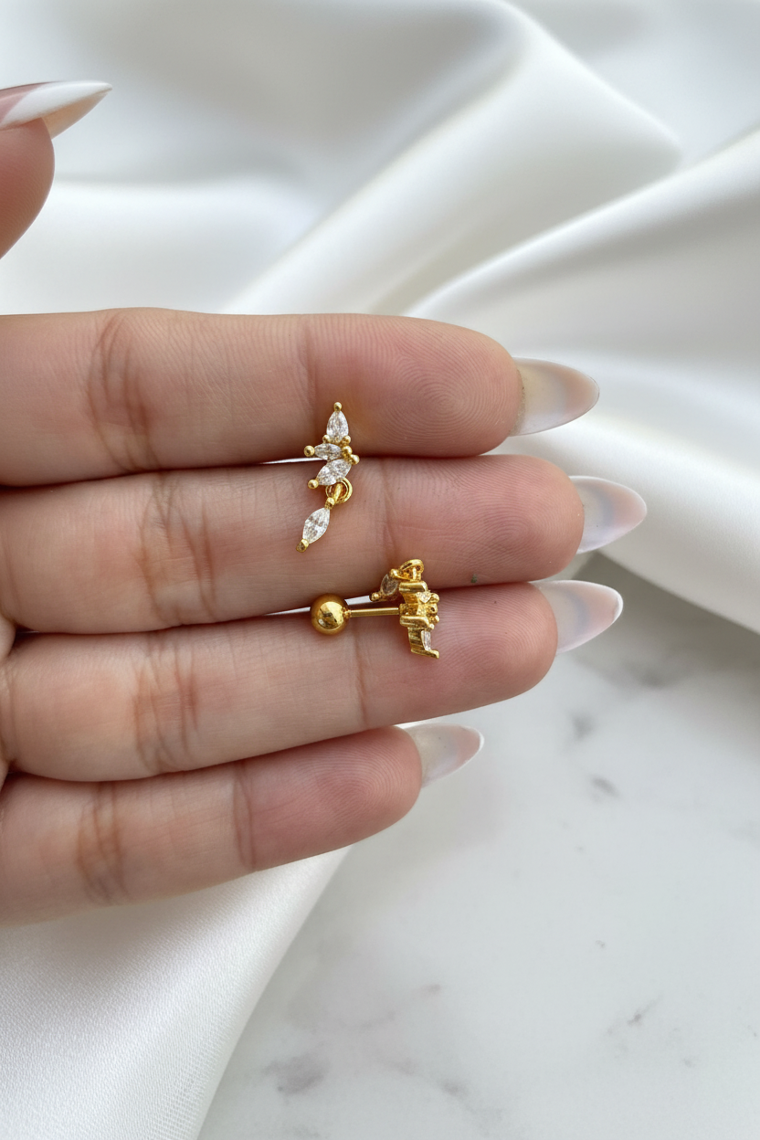Gold crystal butterfly floral drop stud earrings showing front and ball-back closure on white satin marble background