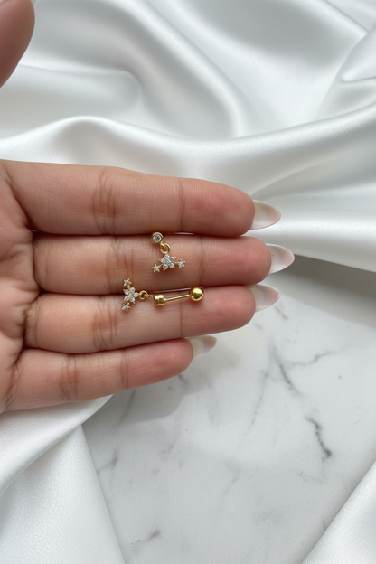 Gold crystal star constellation drop stud earrings showing front and ball-back closure on white satin marble background
