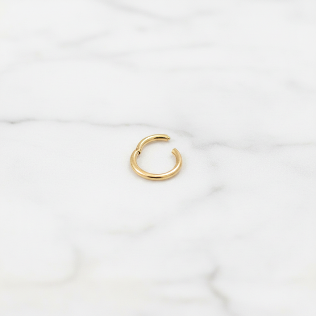 Hania gold nose ring on white marble surface