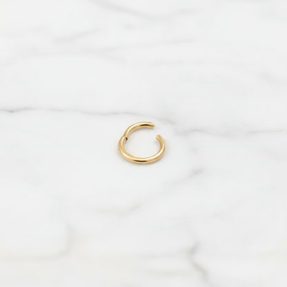 Hania gold nose ring on white marble surface