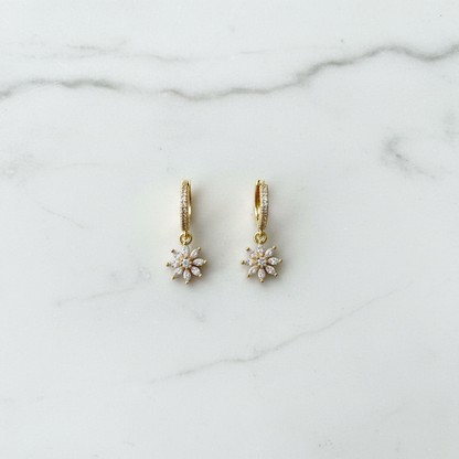 Crystal daisy flower hoop earrings flat lay on white marble