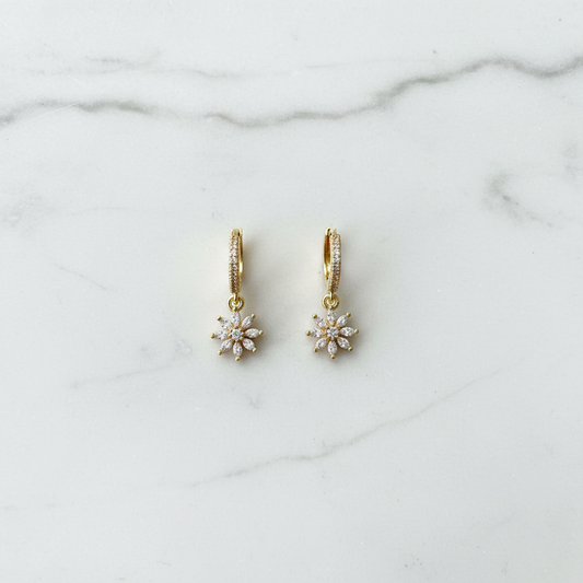 Crystal daisy flower hoop earrings flat lay on white marble