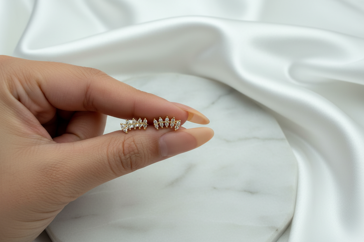 Jennie Studs gold leaf CZ bar earrings on white satin marble background
