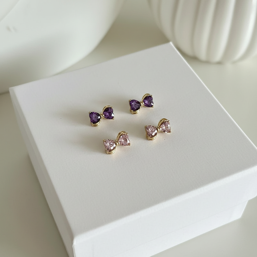 Pink and purple crystal bow earrings on white box