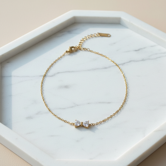 Bow bracelet flat lay on white marble tray – editorial