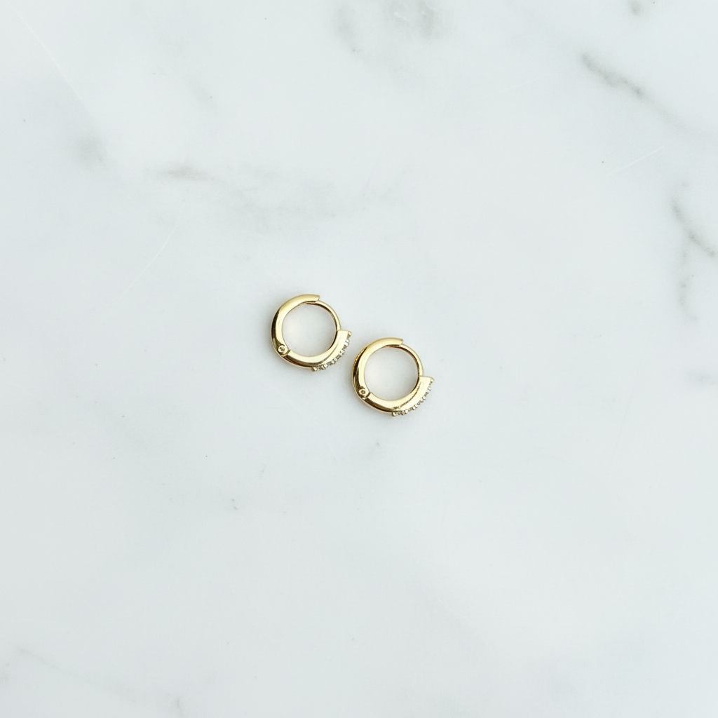 Tara Huggie pavé CZ huggie earrings flat lay on white marble